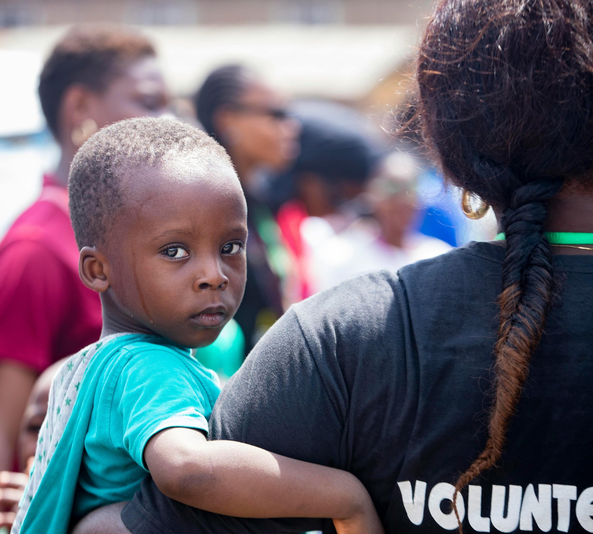 volunteer carrying a child